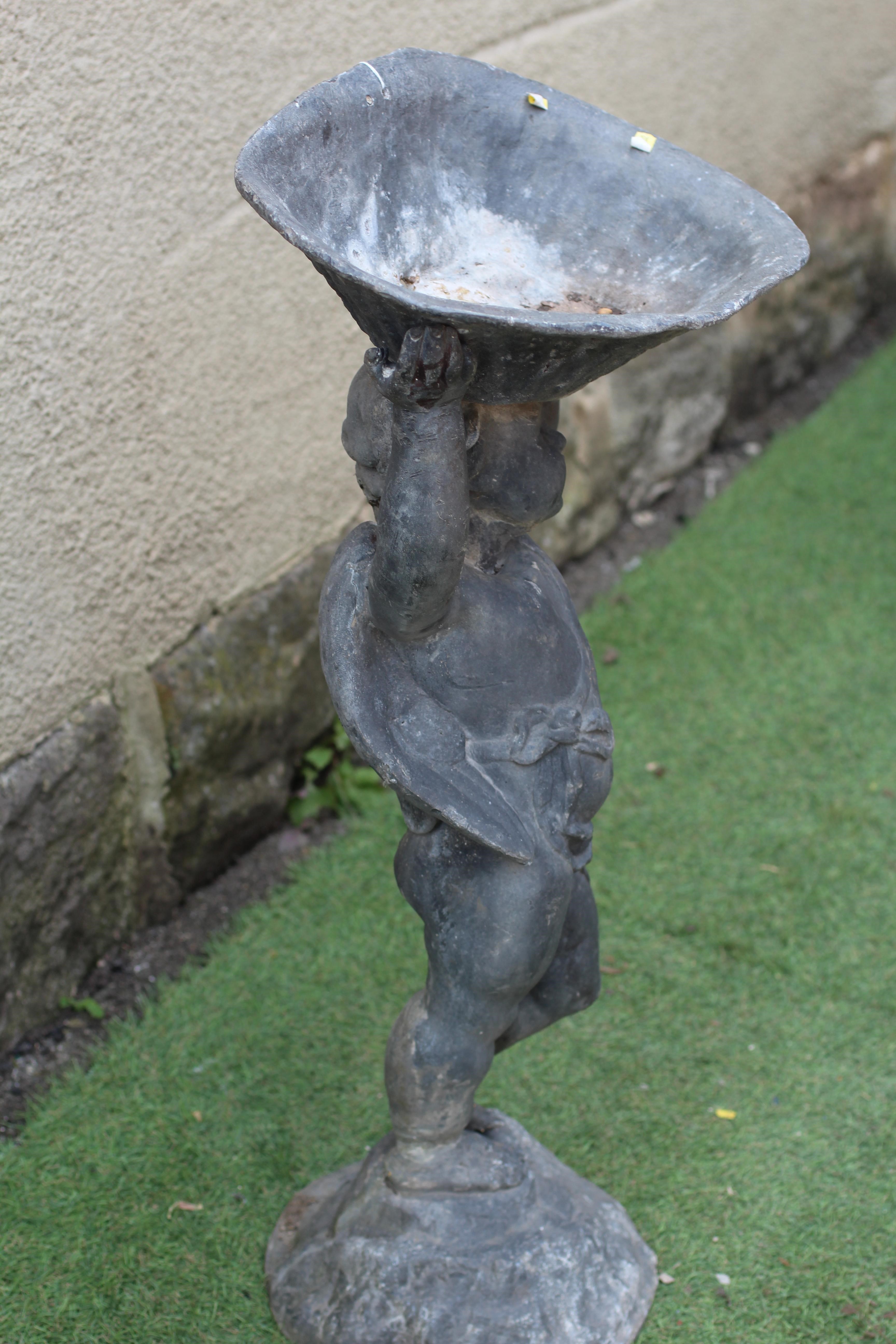 A LEAD FIGURAL BIRD BATH, modern, modelled as a cherub holding aloft a bowl, on domed base, 14 3/4" Image