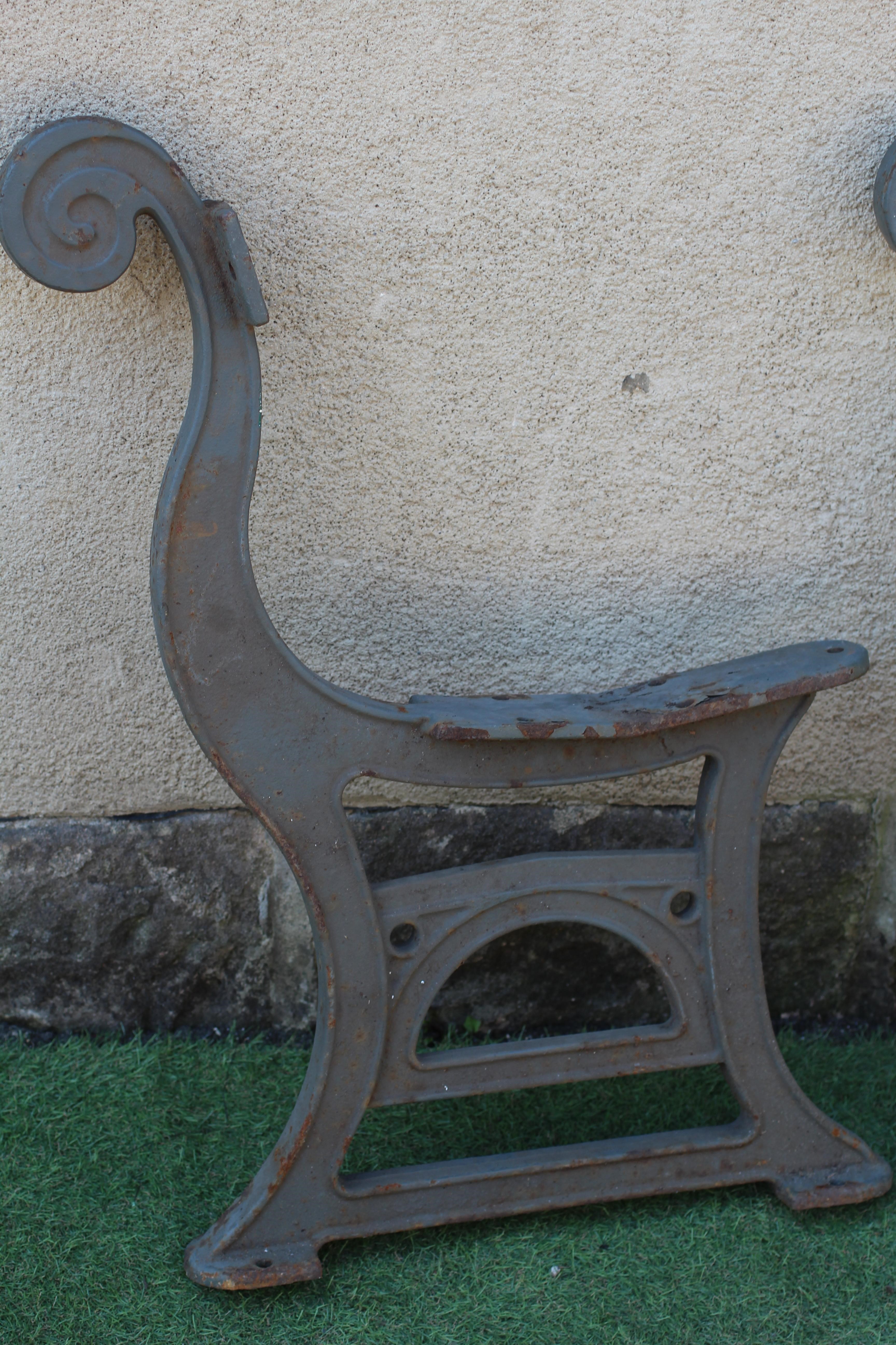 A PAIR OF CAST IRON BENCH ENDS, c.1900, with scrolled back, the channelled base with arched panel Image
