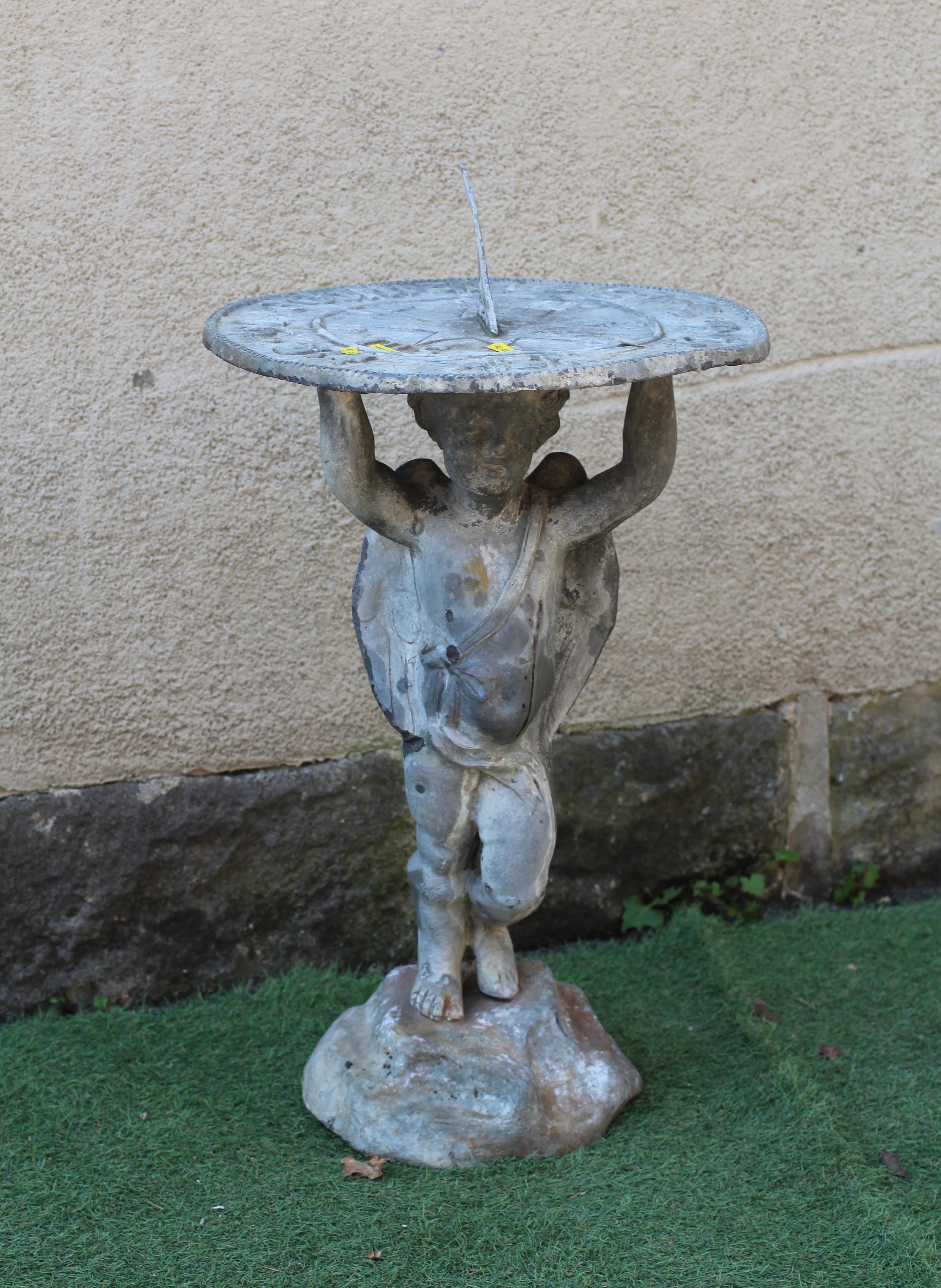 A LEAD FIGURAL SUNDIAL, modern, held aloft by a cherub, on domed base, 16 1/2" w x 31" h Image