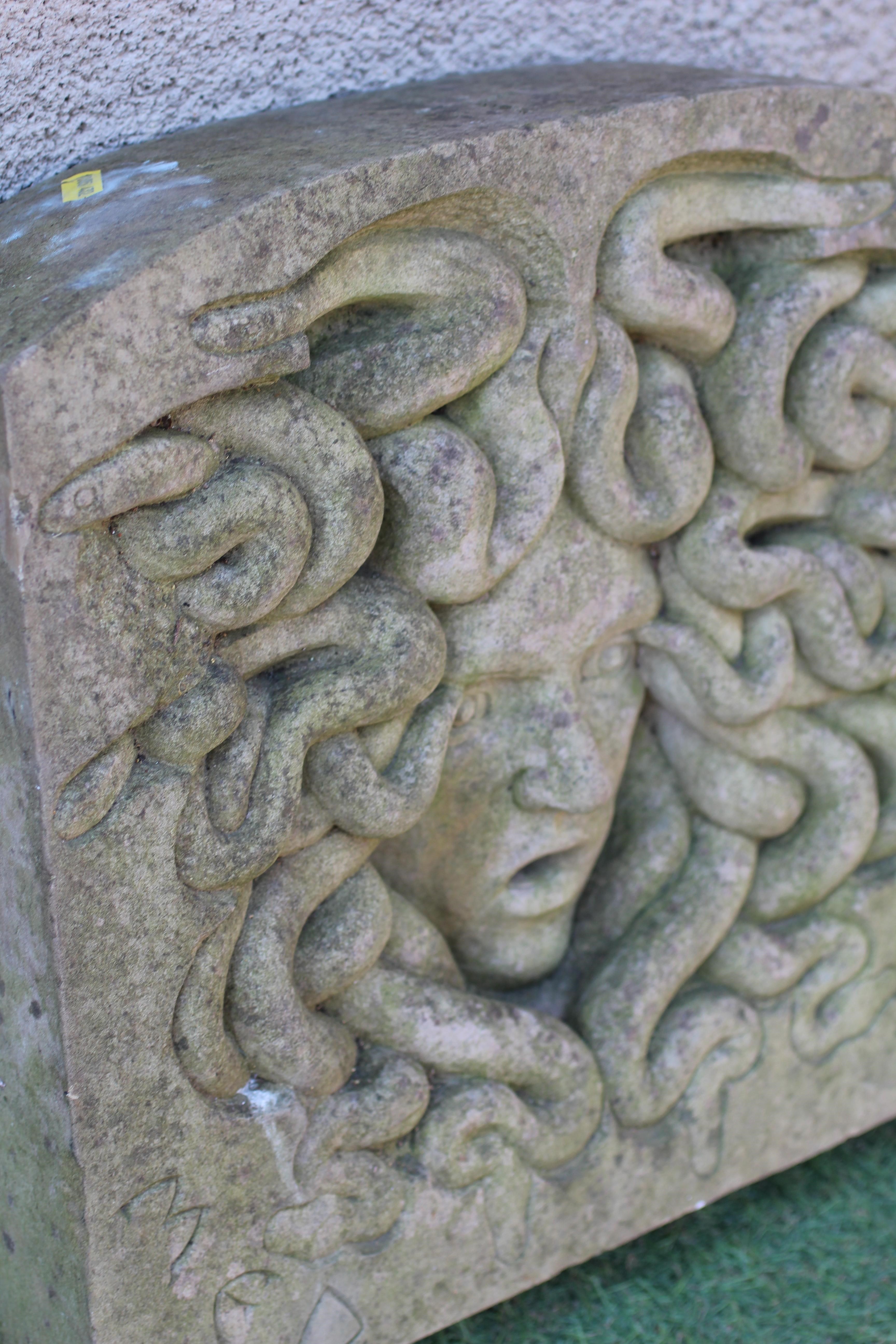 A CARVED SANDSTONE WALL PLAQUE of arched oblong form and depicting the head of Medusa, inscribed Image