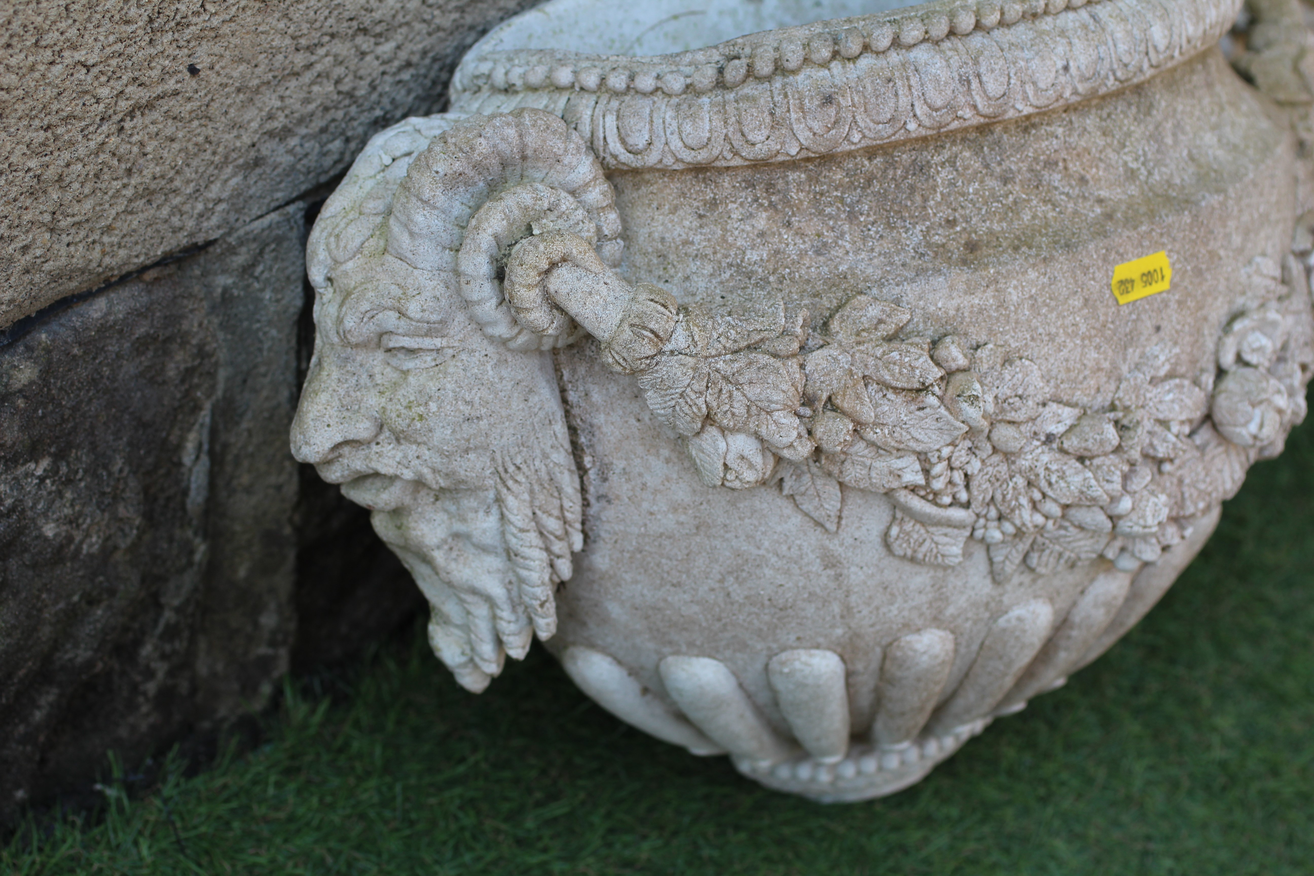 A PAIR OF CAST STONE WALL PLANTERS of demi lune half fluted form with Bacchanalian masks at either Image