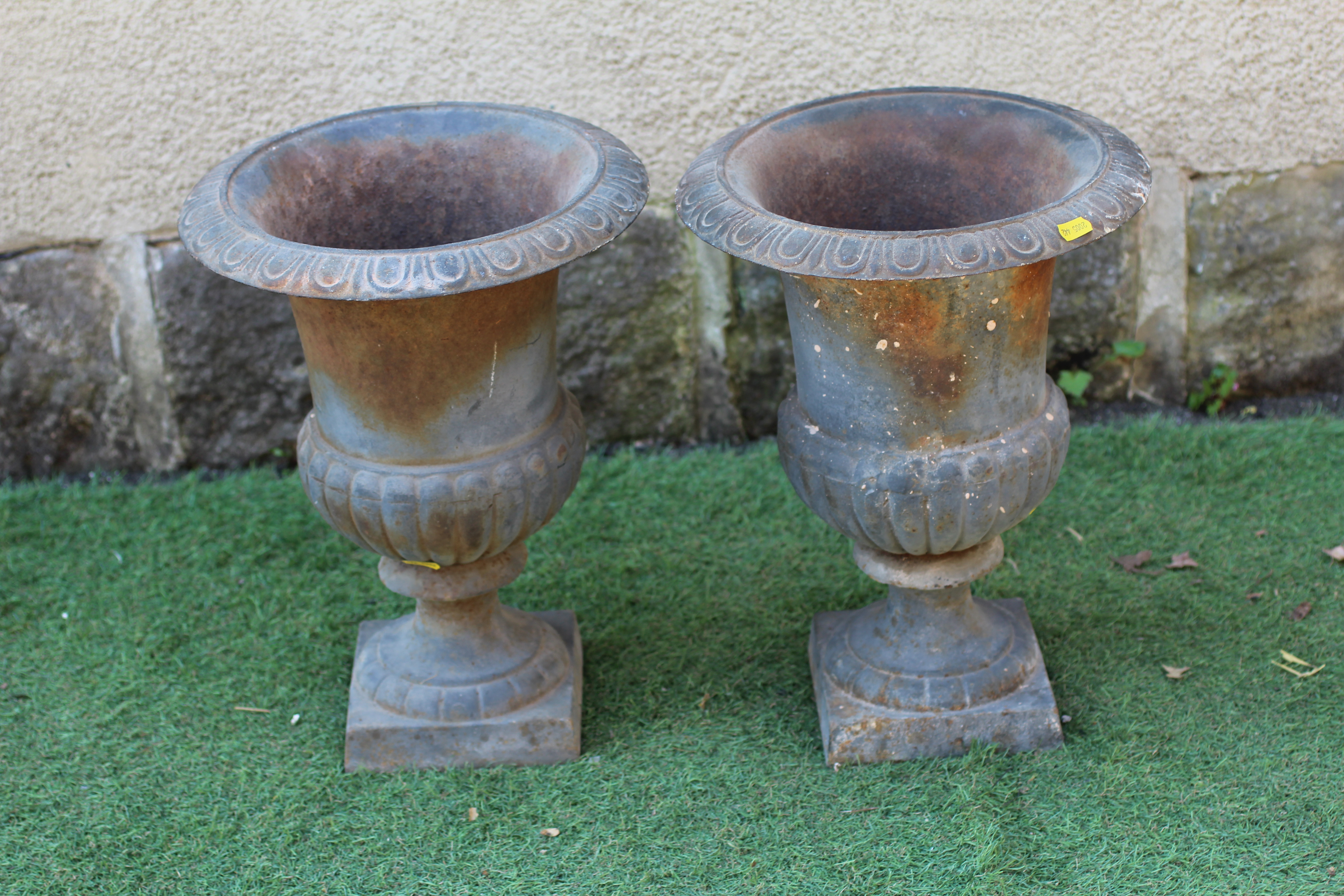 A PAIR OF SMALL CAST IRON URNS, modern, of half fluted campana form with egg and dart moulded rim, Image