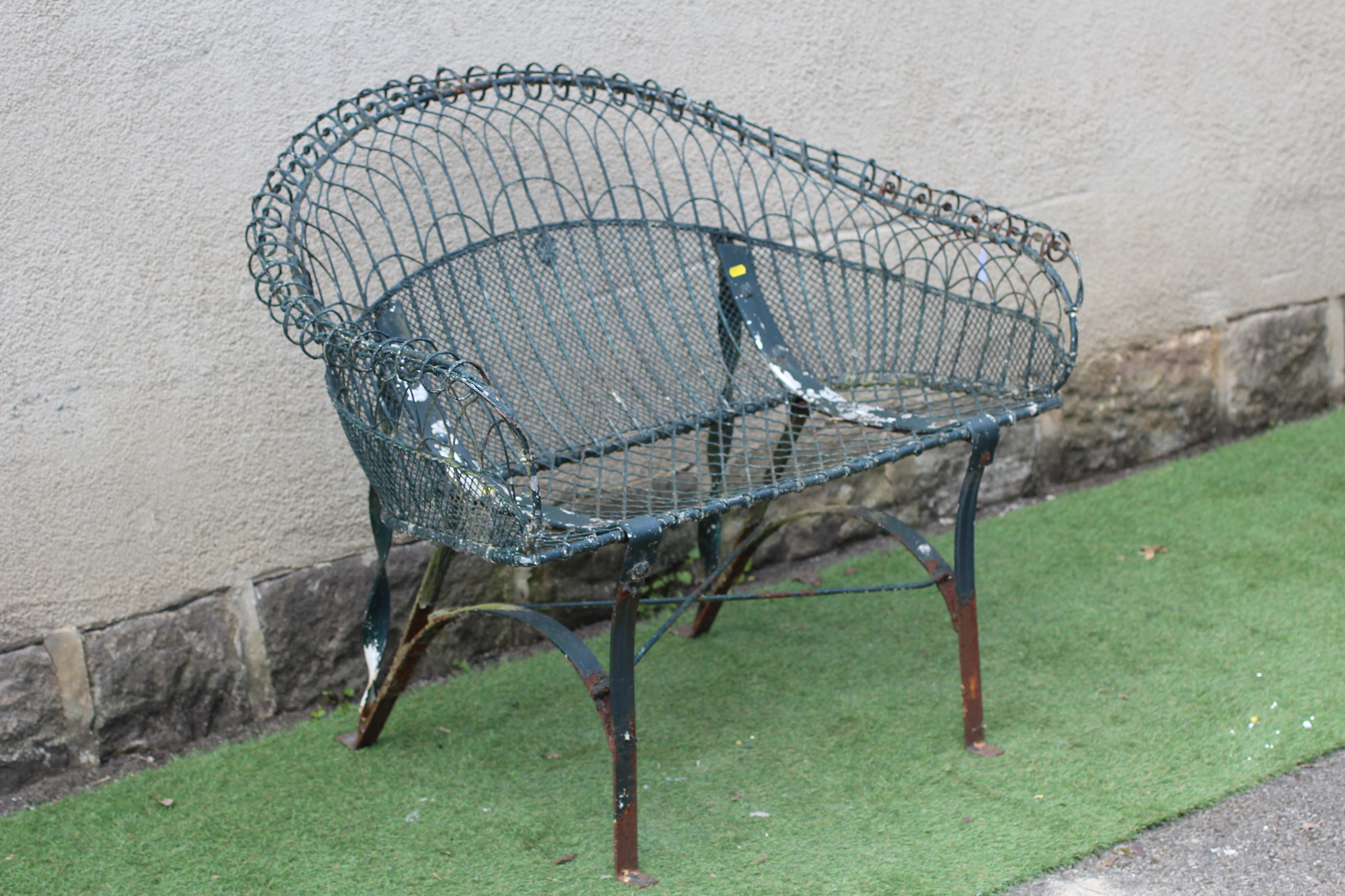 A WIREWORK BENCH with arched trellis patterned scroll over back and arms, on strapwork supports Image