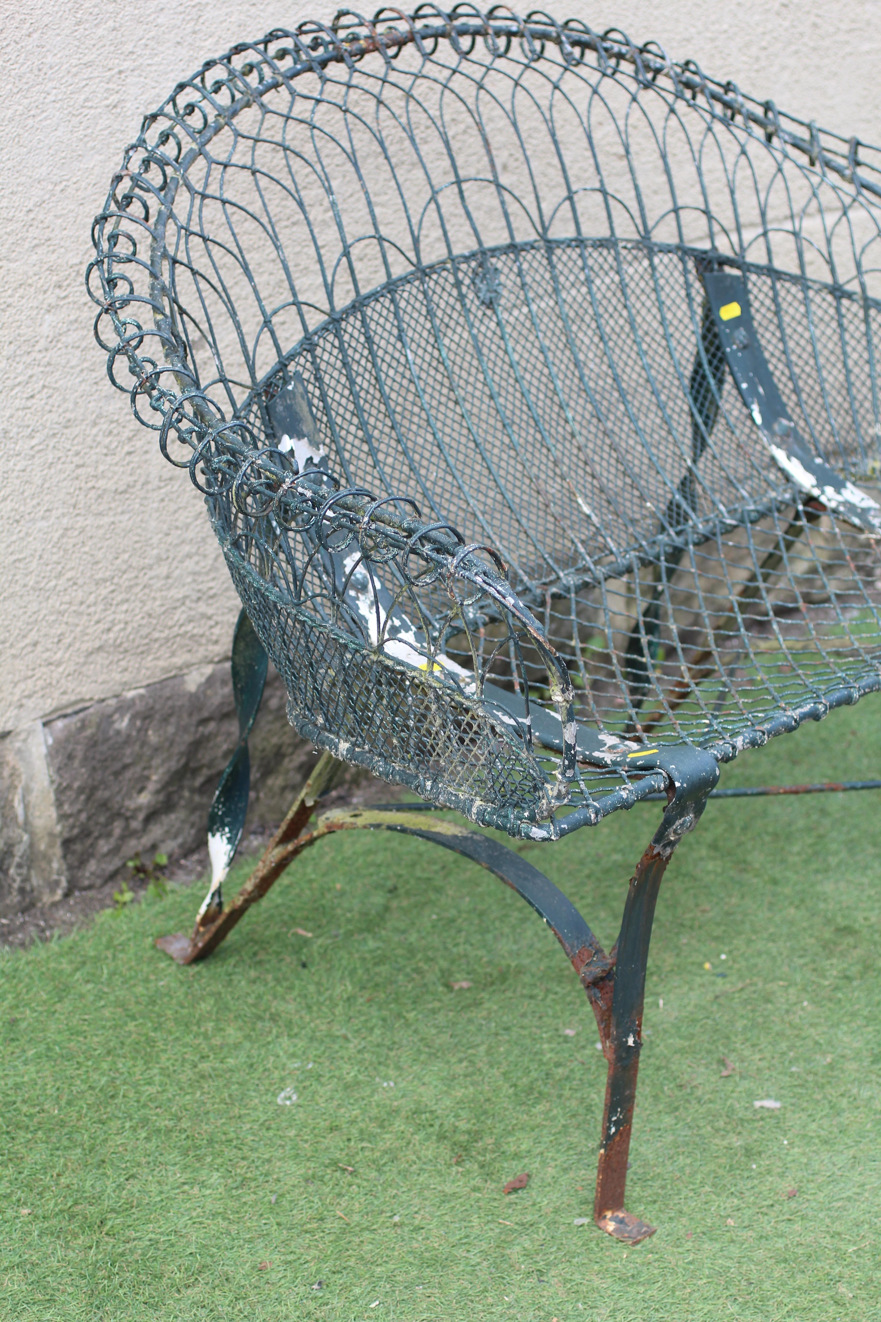 A WIREWORK BENCH with arched trellis patterned scroll over back and arms, on strapwork supports Image