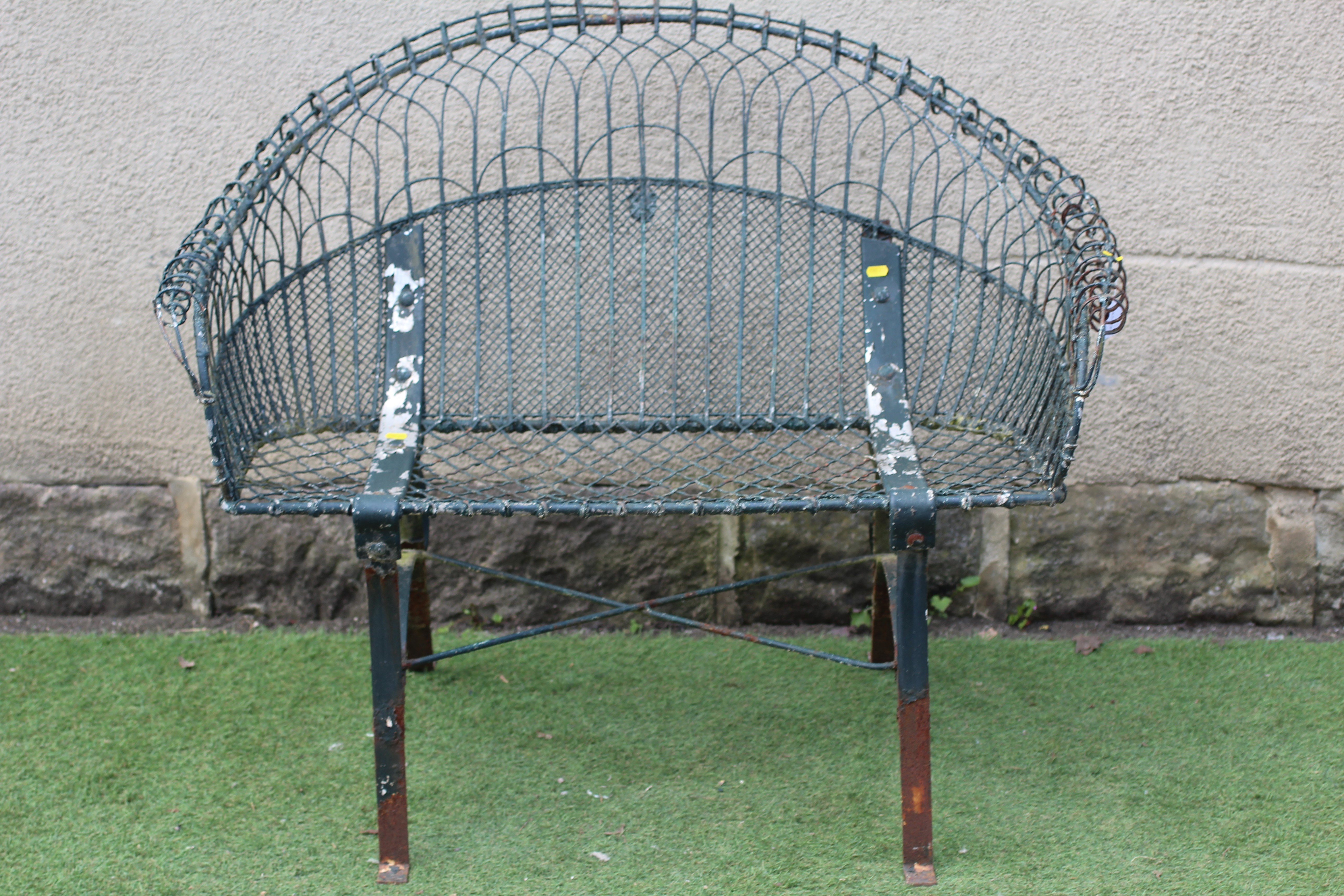 A WIREWORK BENCH with arched trellis patterned scroll over back and arms, on strapwork supports Image