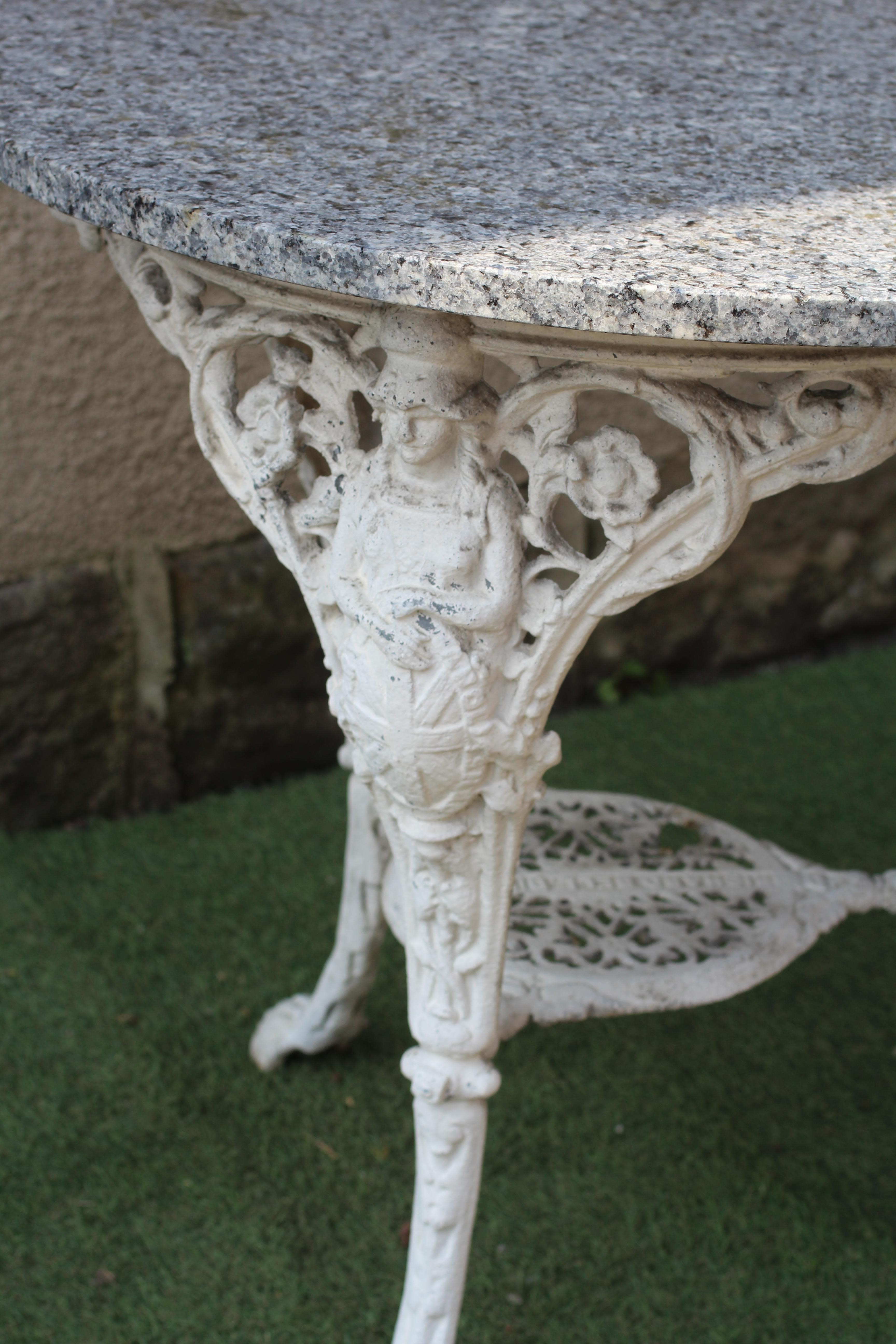 A VICTORIAN CAST IRON BRITANNIA PATTERN PUB TABLE with later circular granite top, the undershelf Image