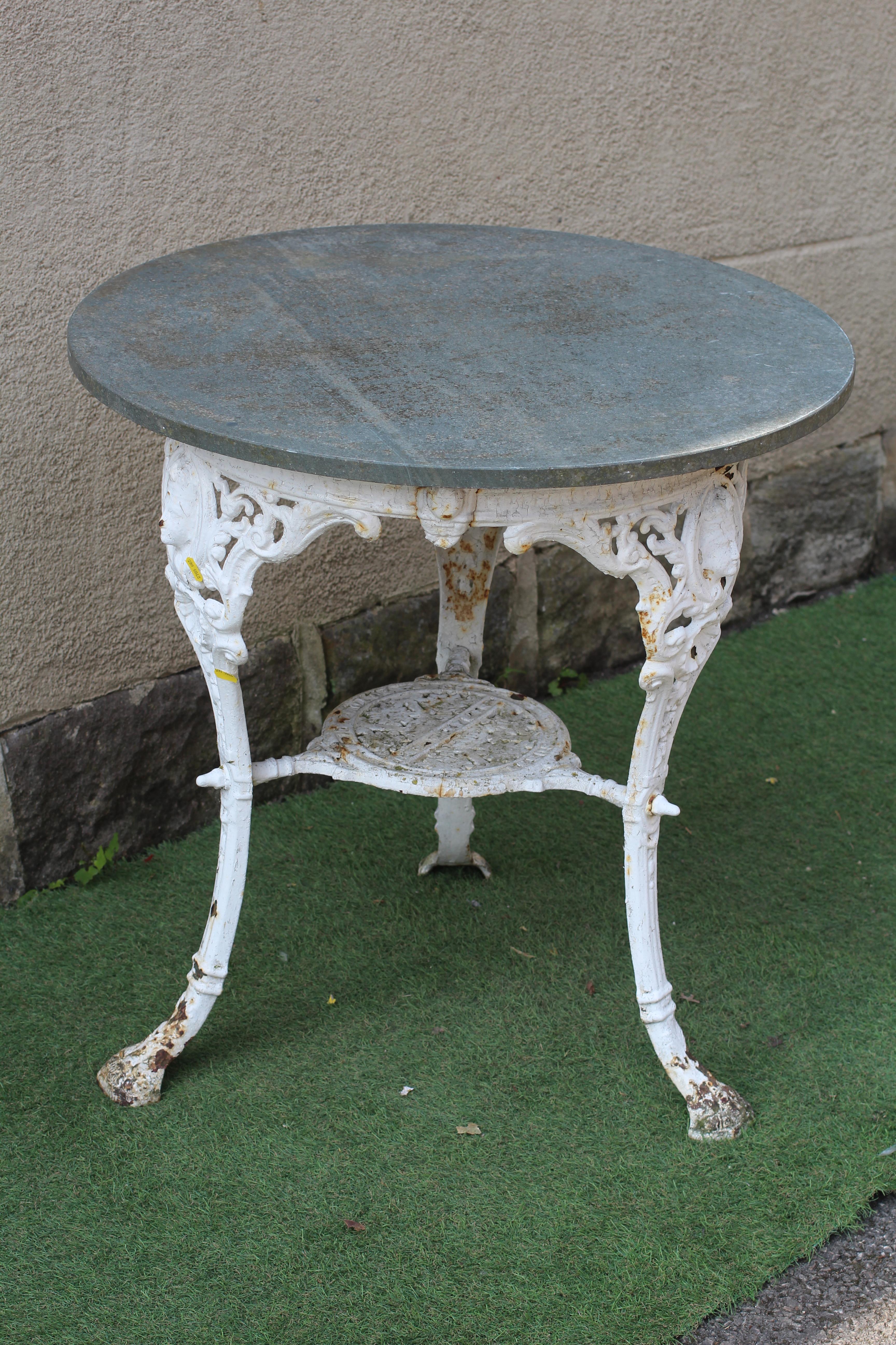 A VICTORIAN CAST IRON PUB TABLE, the later circular slate top on mask headed legs and paw feet Image