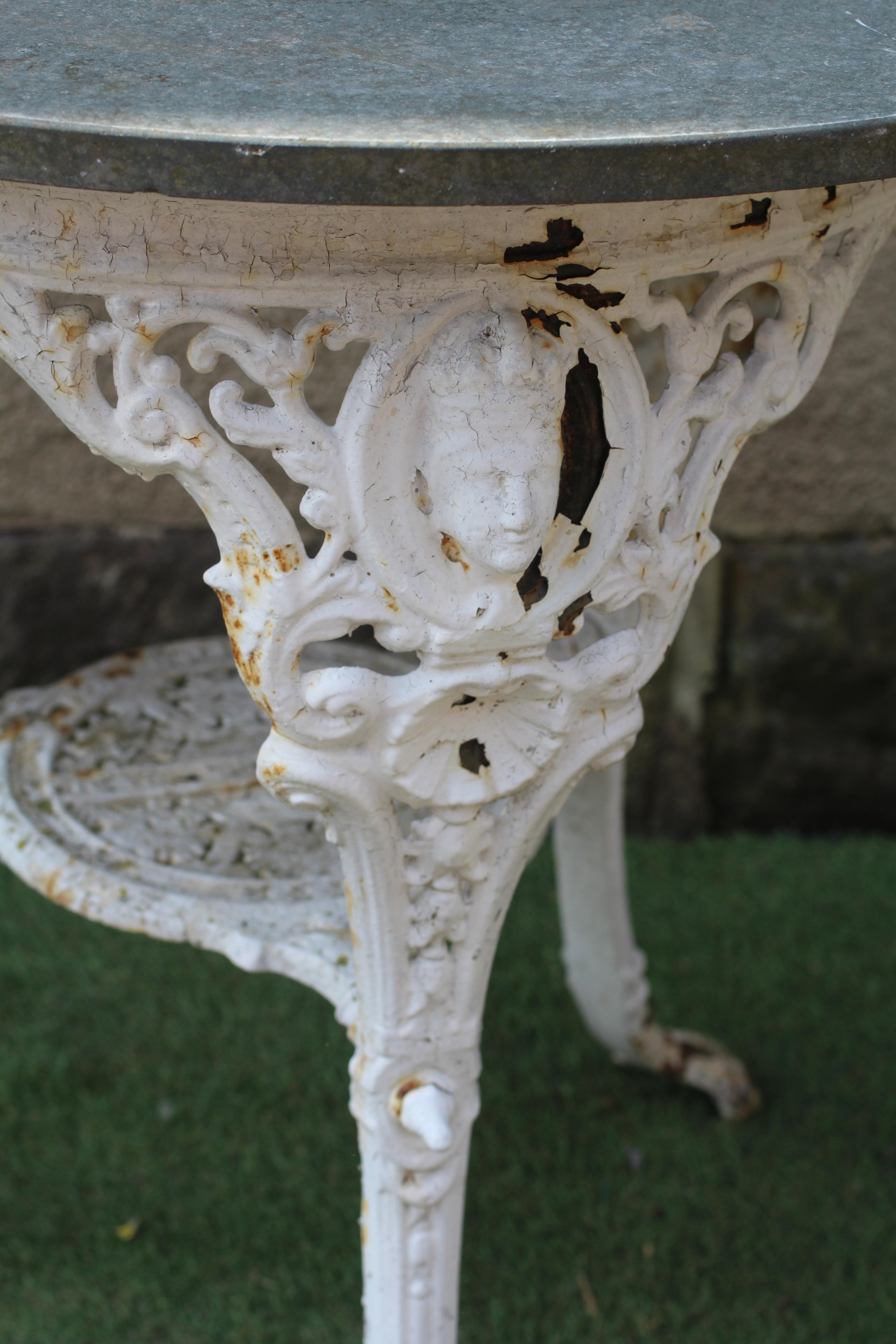 A VICTORIAN CAST IRON PUB TABLE, the later circular slate top on mask headed legs and paw feet Image