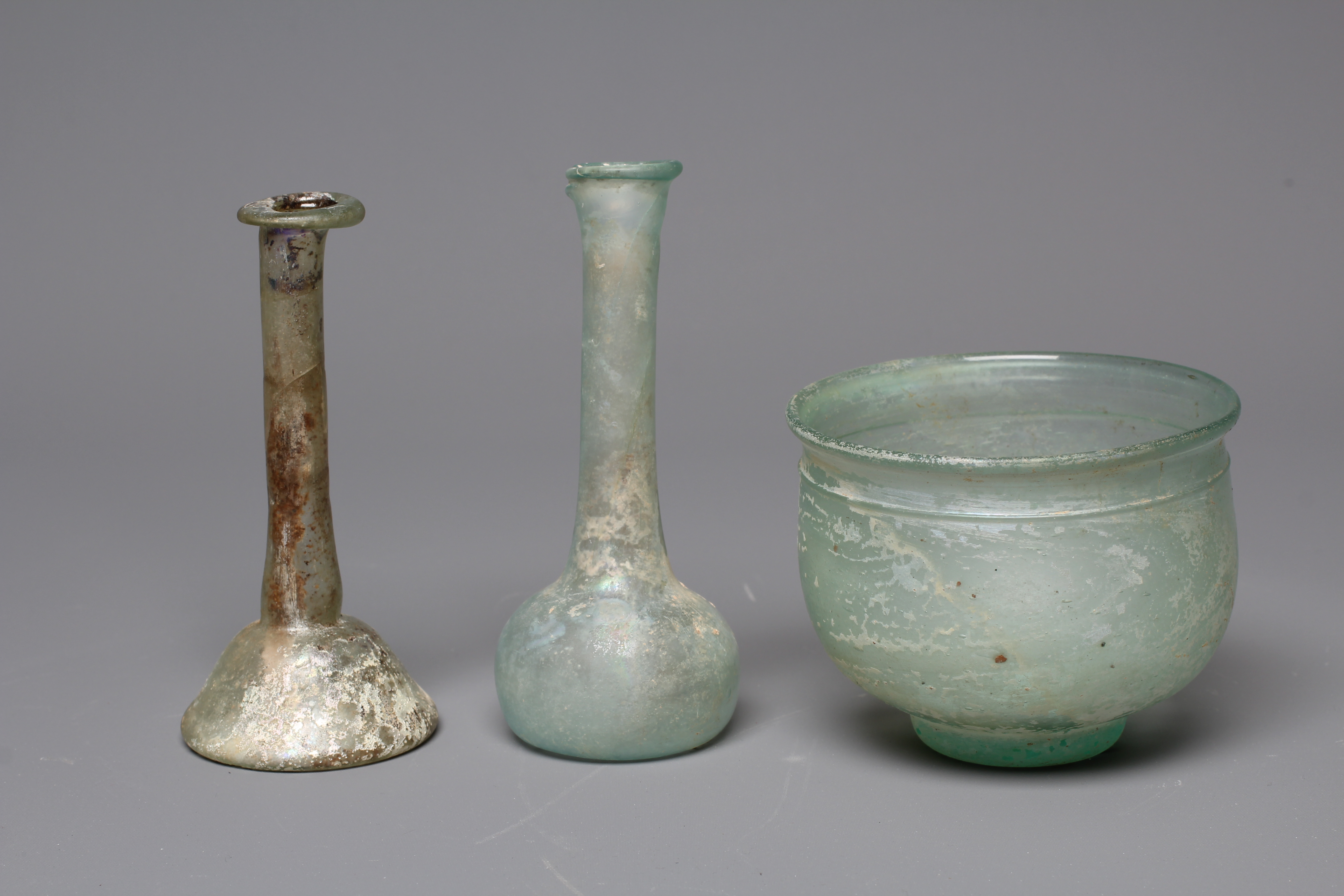 A ROMAN GREEN GLASS UNGUENTARIUM Image