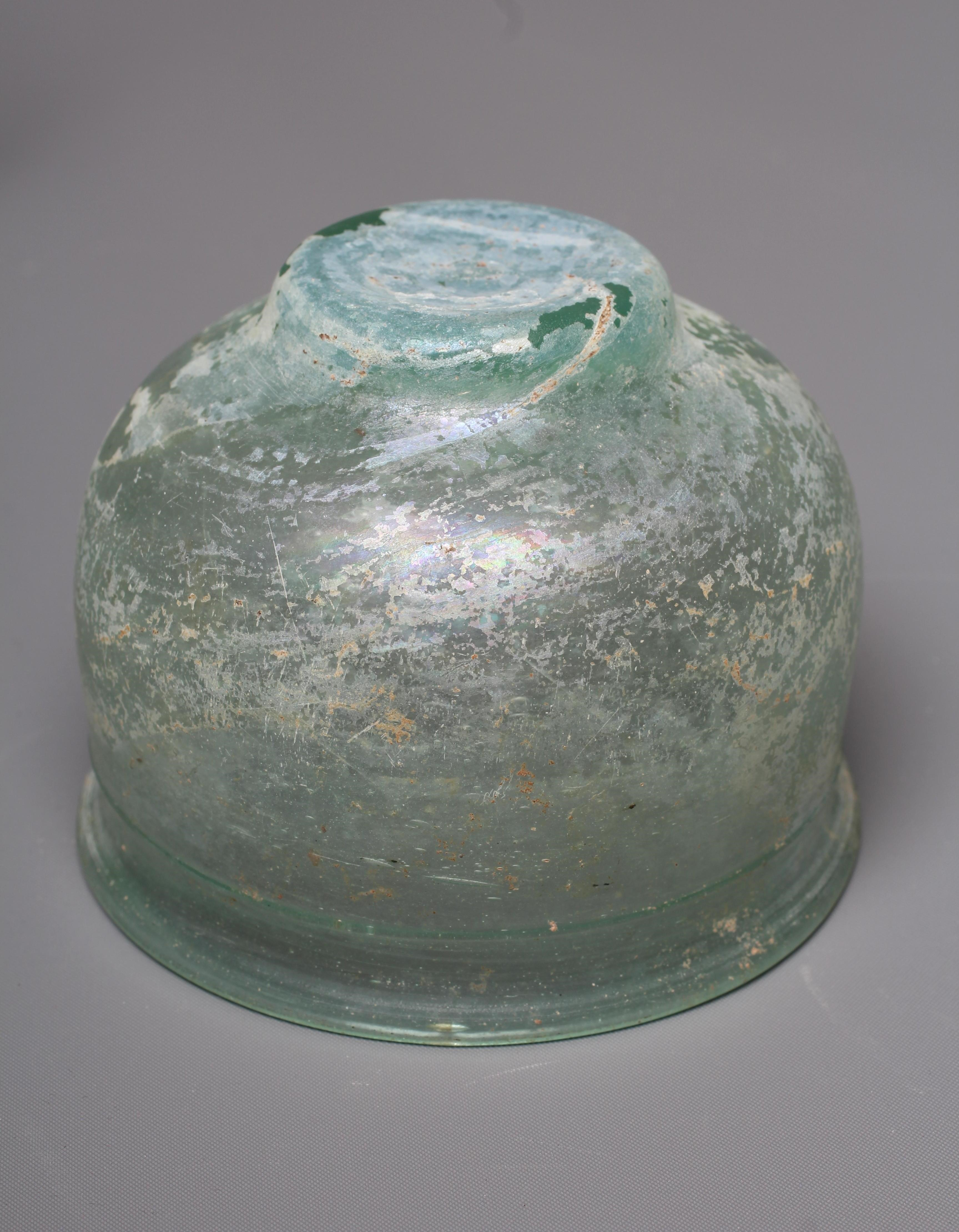 A ROMAN GREEN GLASS UNGUENTARIUM Image