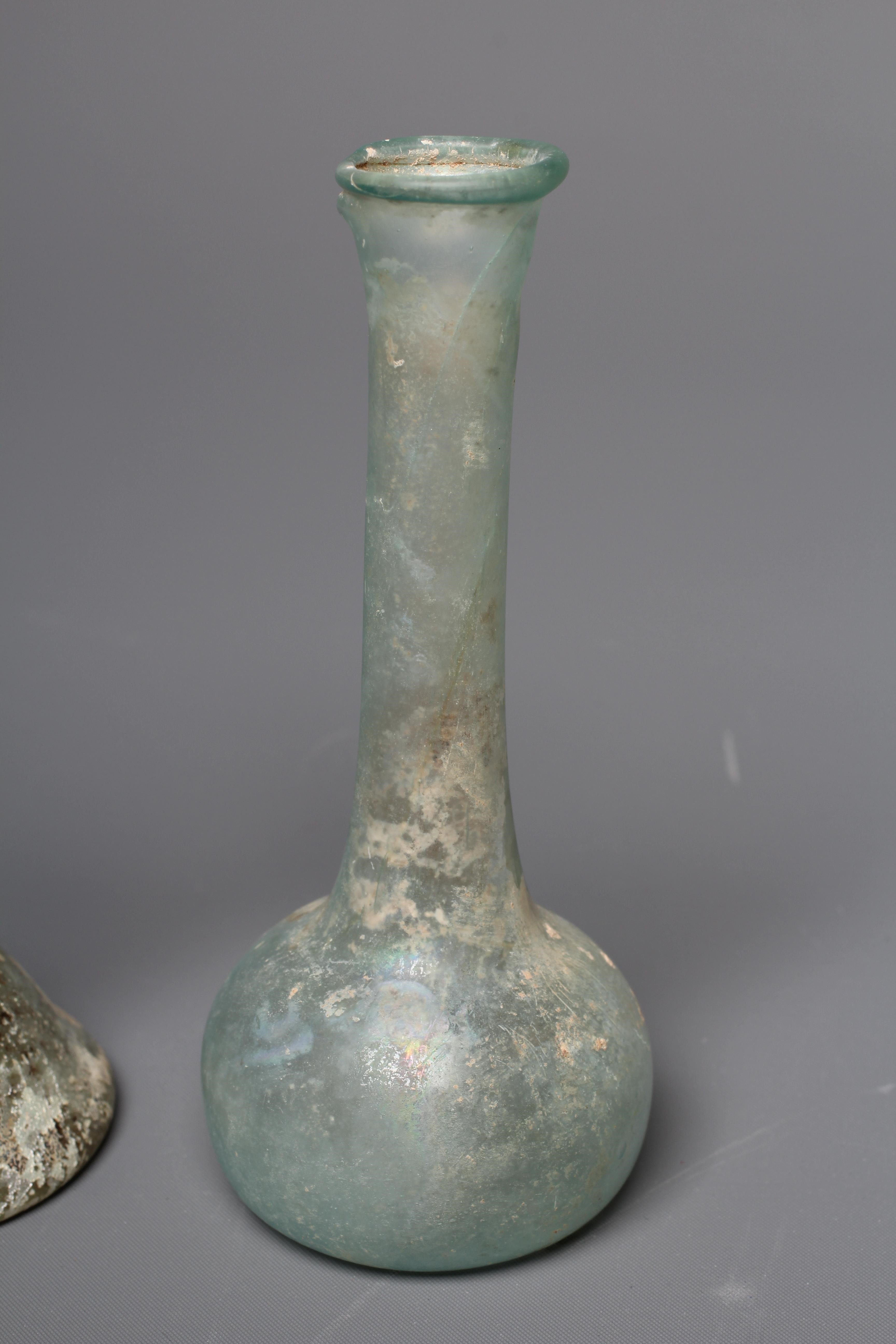 A ROMAN GREEN GLASS UNGUENTARIUM Image