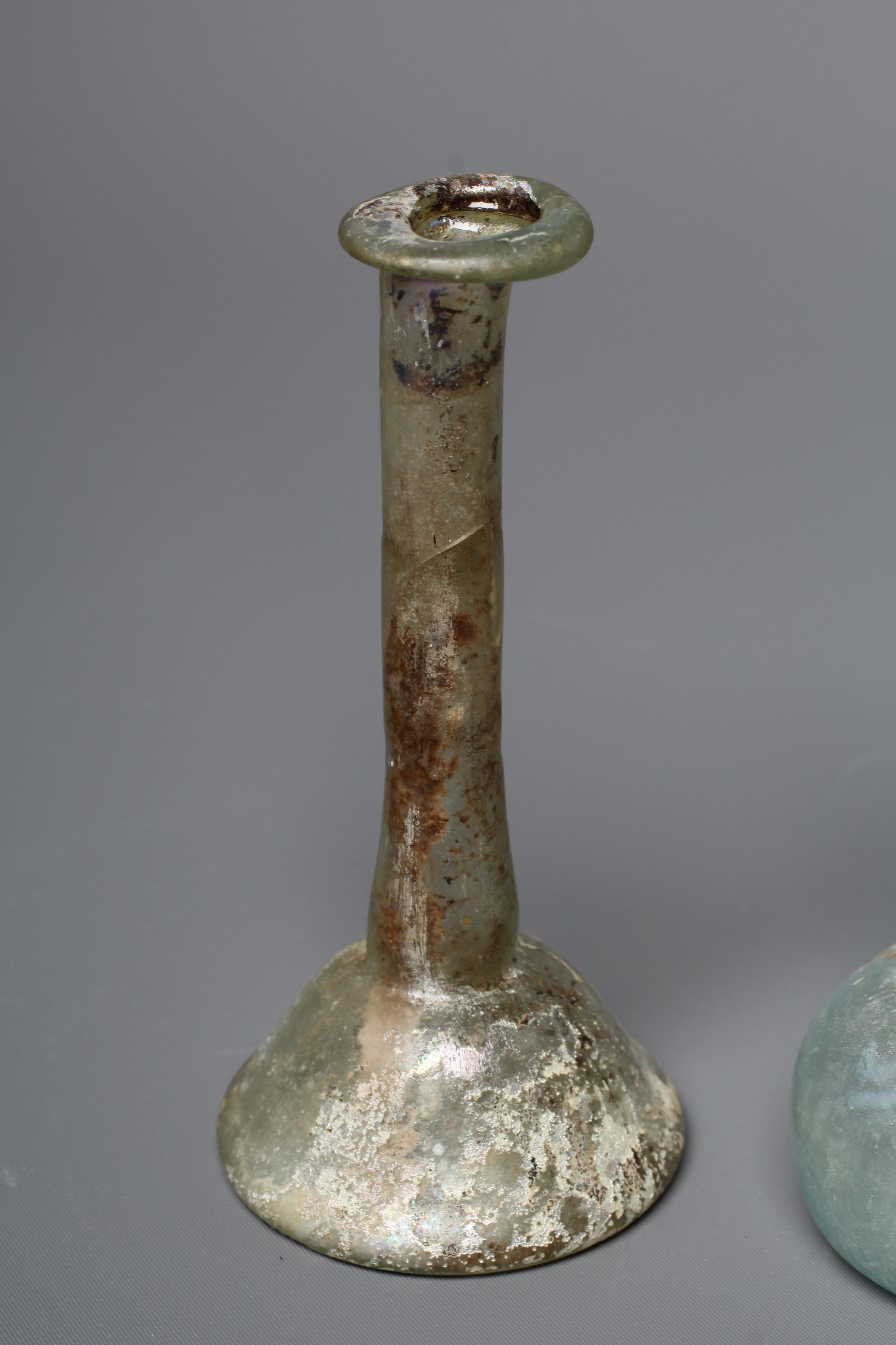 A ROMAN GREEN GLASS UNGUENTARIUM Image