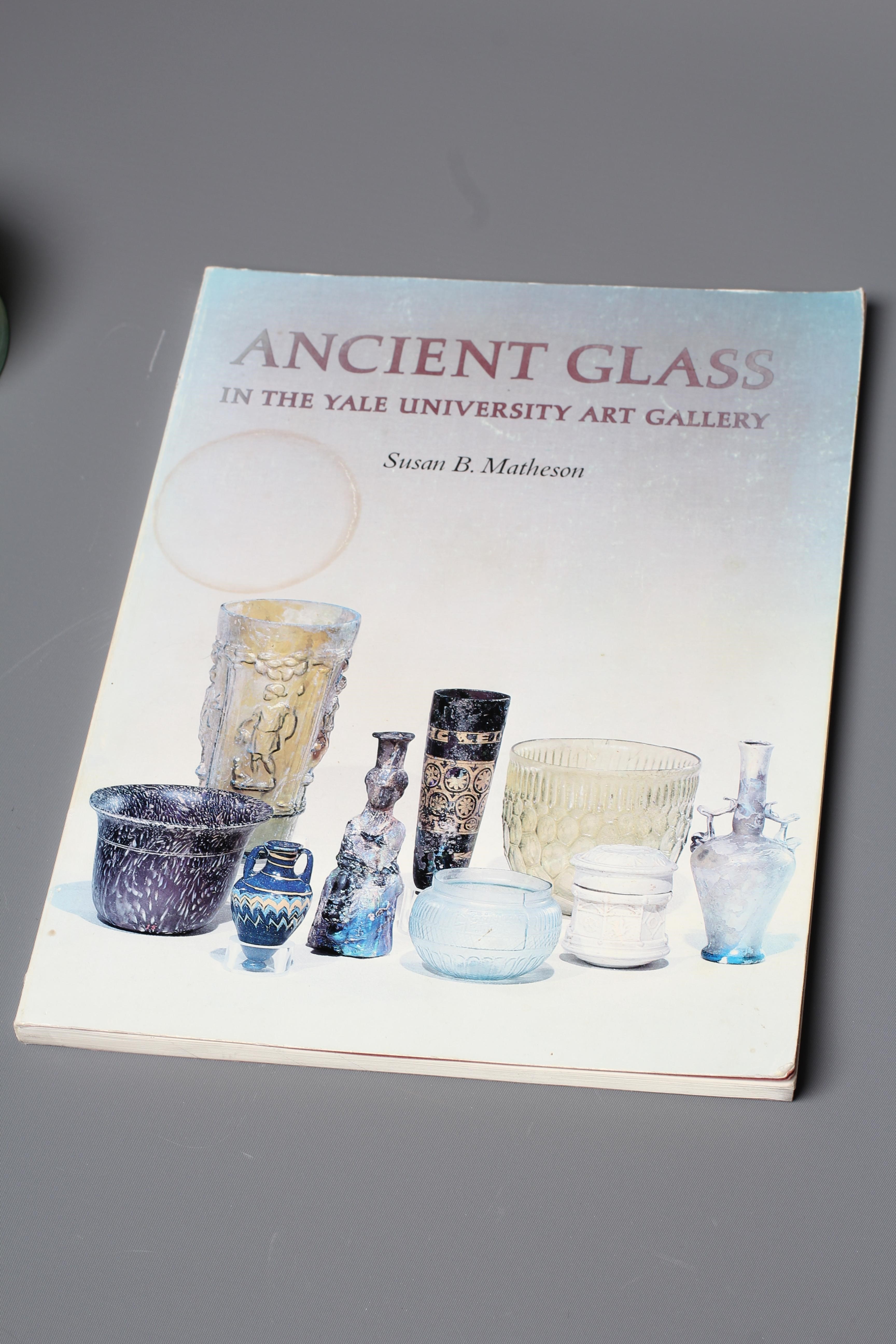 A ROMAN GREEN GLASS UNGUENTARIUM Image