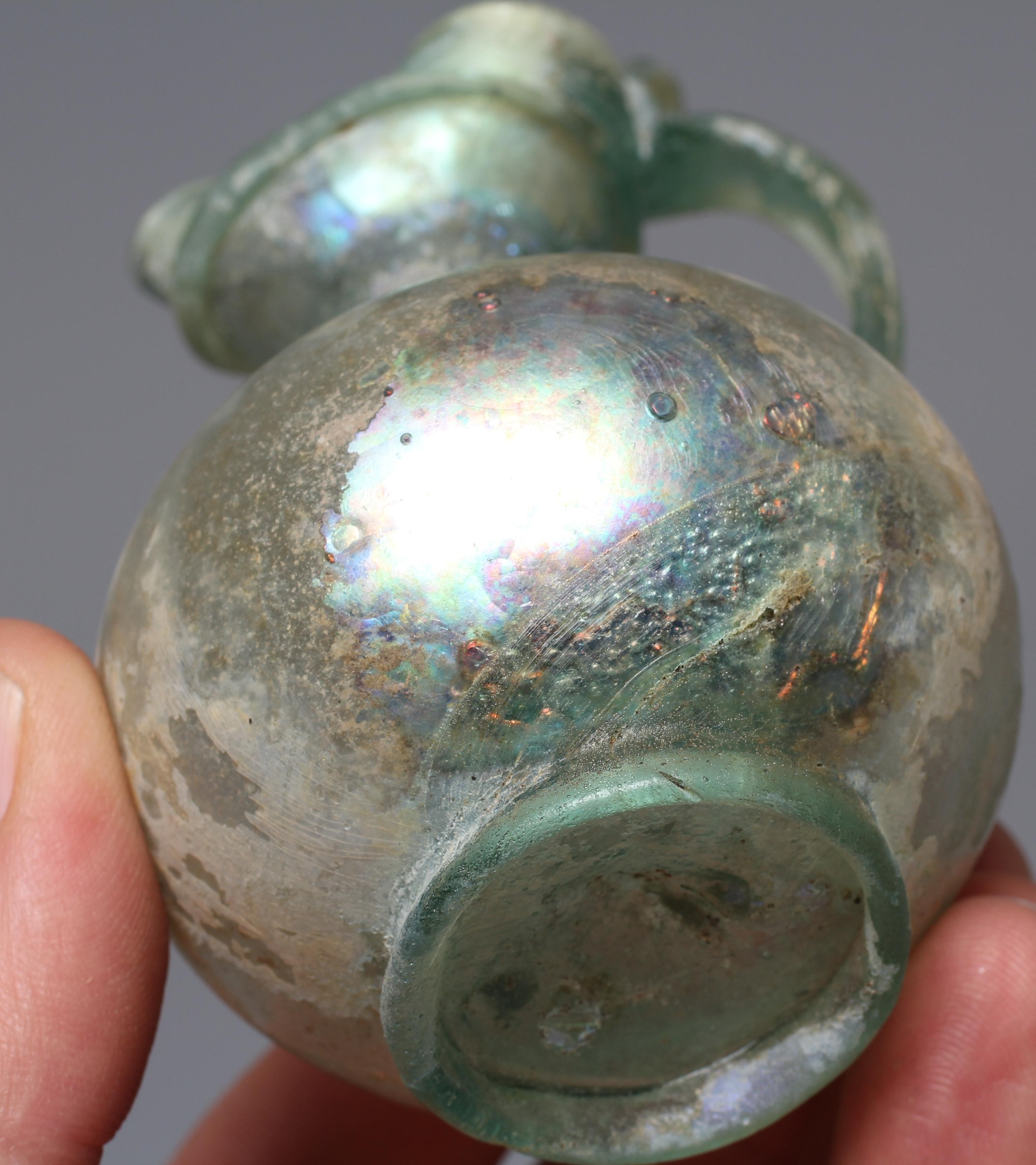 A ROMAN GREEN GLASS JUG, 3rd-4th century AD, with trefoil lip and pulled handle, 3 1/2" high, Image