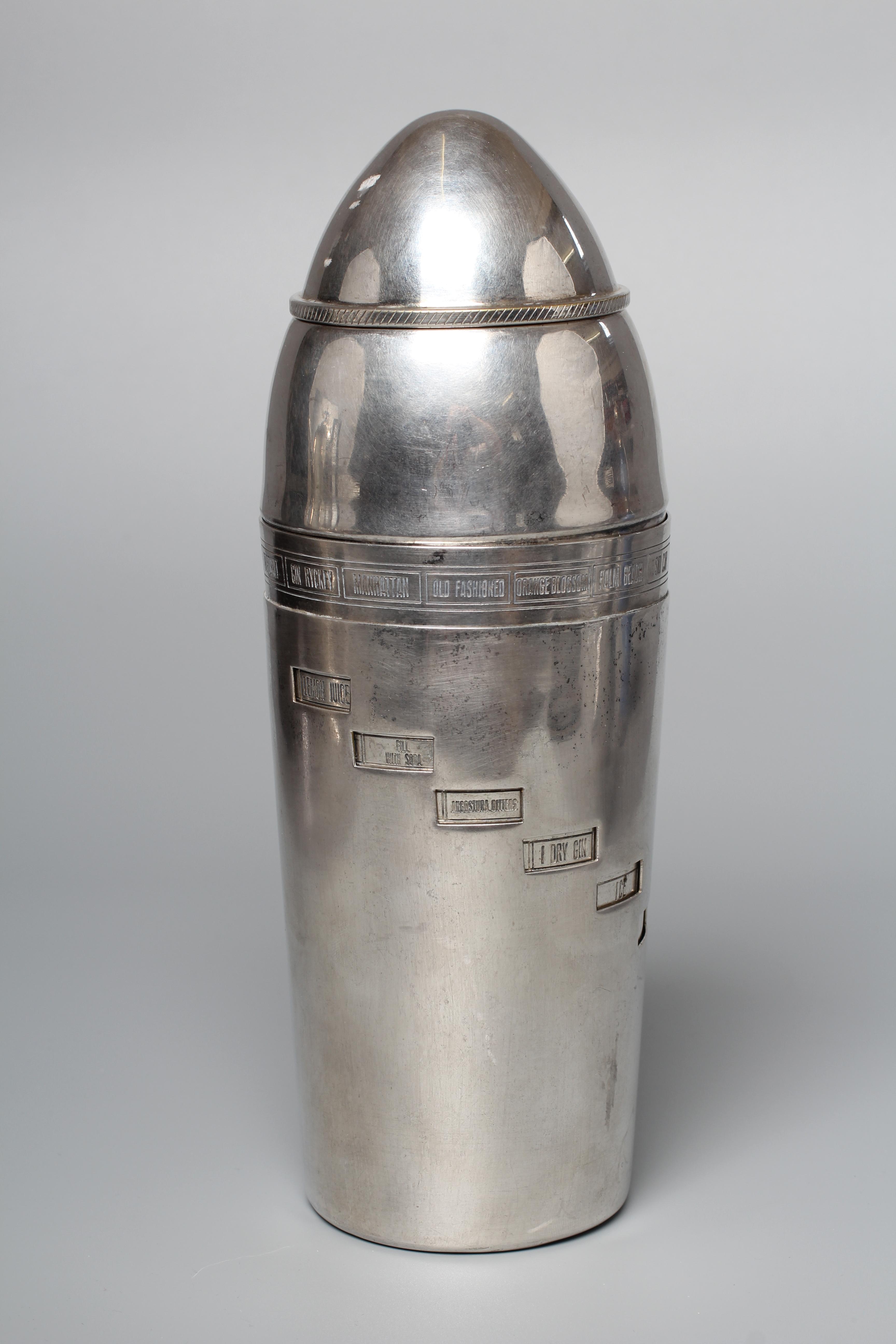 AN ART DECO TORPEDO SHAPED RECIPE COCKTAIL SHAKER by Wilhelm Wolf, the rim with fifteen named Image