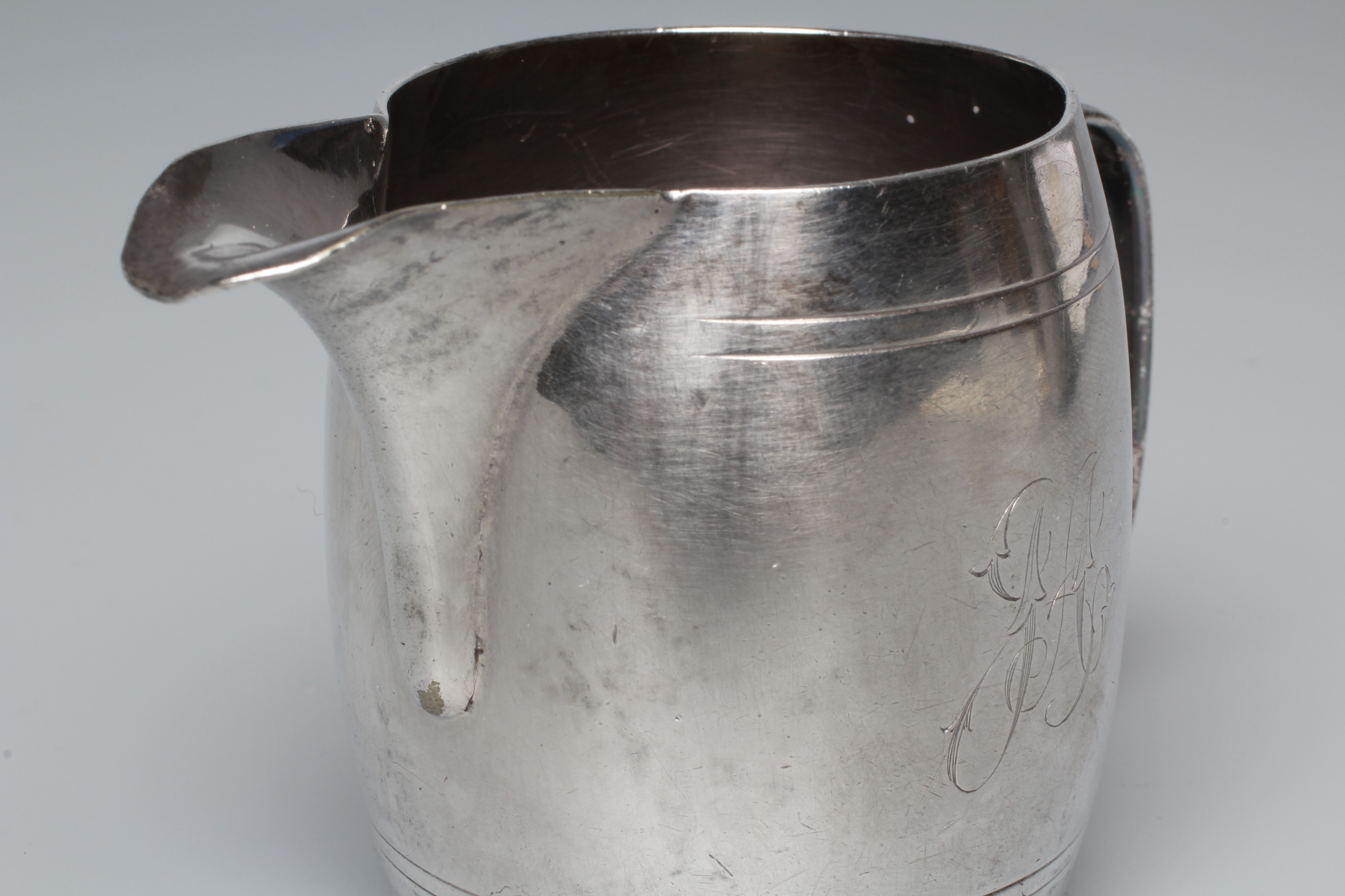 A GEORGE V ART DECO CREAM JUG by Deykin & Harrison, Birmingham 1933, of barrel form with engraved Image
