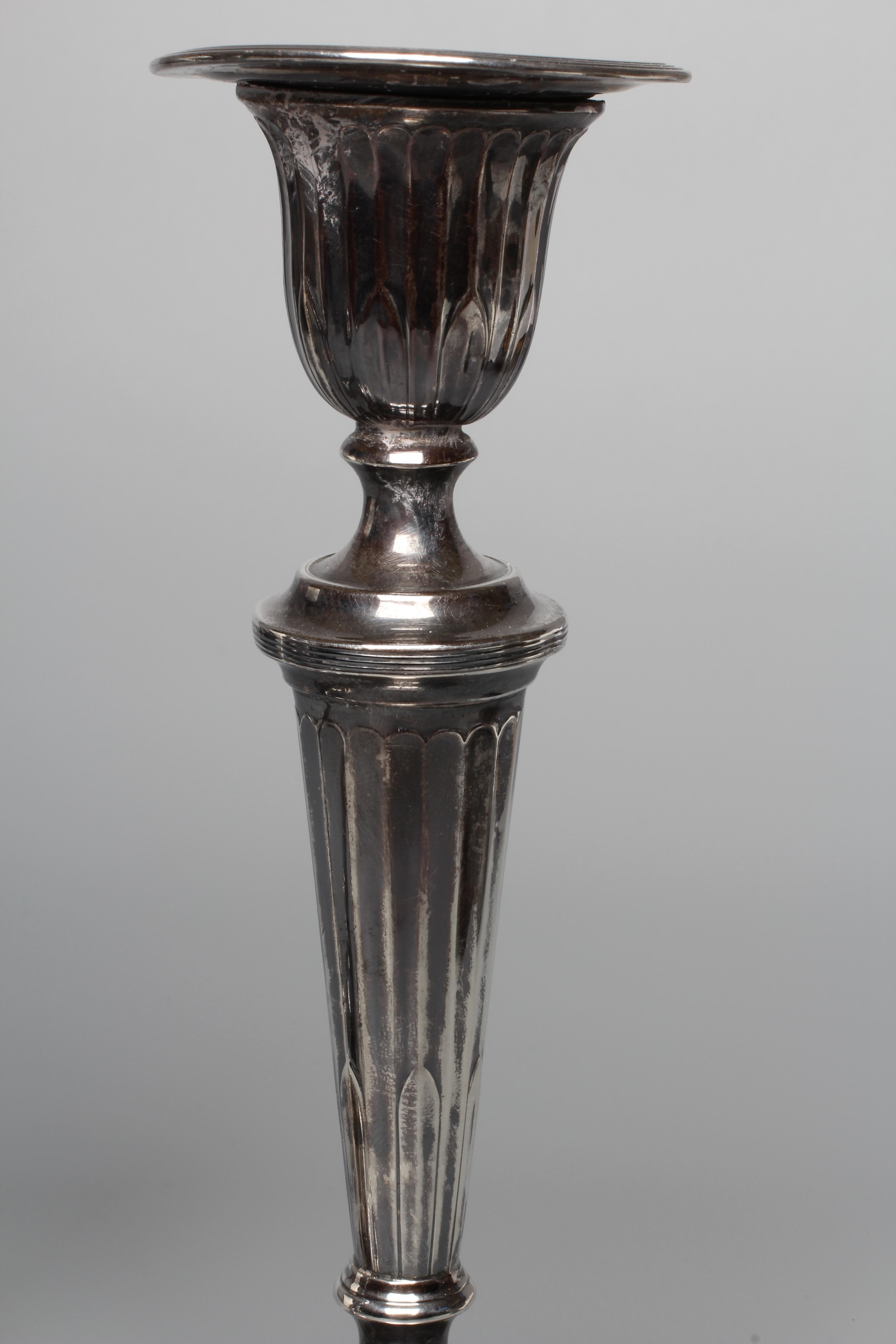 A PAIR OF GEORGE V CANDLESTICKS by Thomas Bradbury and retailed by Barraclough of Leeds Image