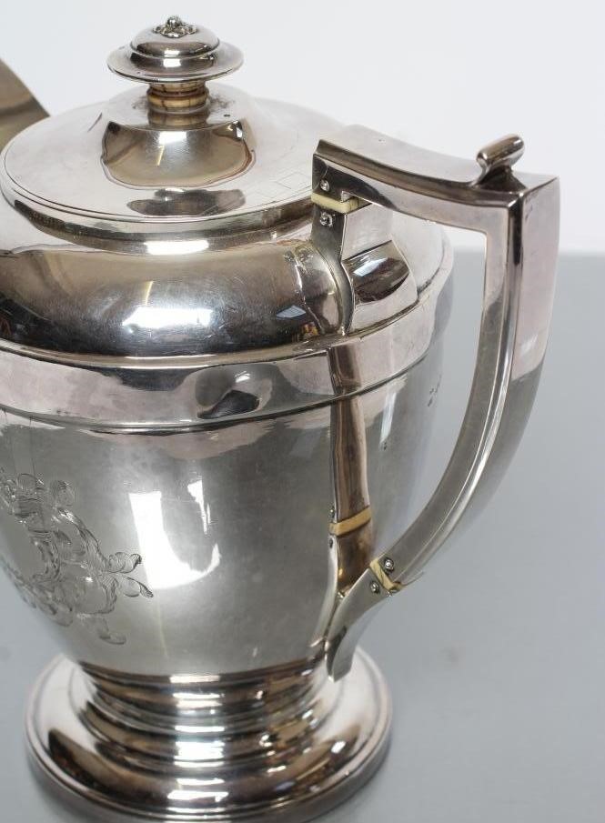 A LATE GEORGE III SILVER HOT WATER JUG Image