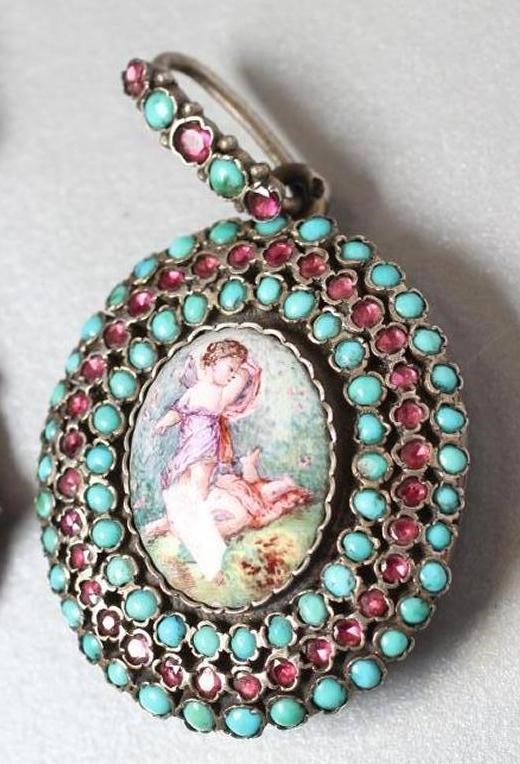 A VICTORIAN PENDANT LOCKET centrally set with an oval enamel plaque painted with two cupids fighting Image