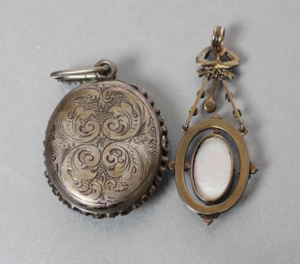 A VICTORIAN PENDANT LOCKET centrally set with an oval enamel plaque painted with two cupids fighting Image