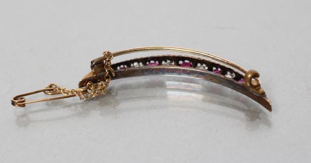AN EDWARDIAN RUBY AND DIAMOND CRESCENT BROOCH alternately claw set with five graduated rubies and Image
