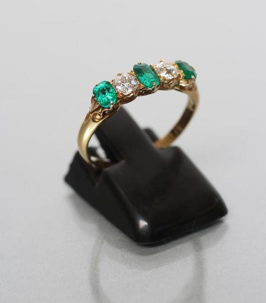 AN EMERALD AND DIAMOND FIVE STONE RING Image