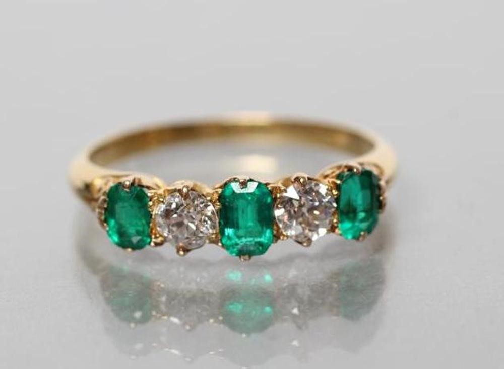 AN EMERALD AND DIAMOND FIVE STONE RING Image