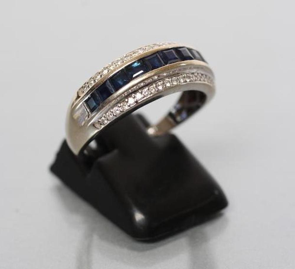 A SAPPHIRE AND DIAMOND HALF HOOP RING channel set with ten square cut sapphires with a border of Image