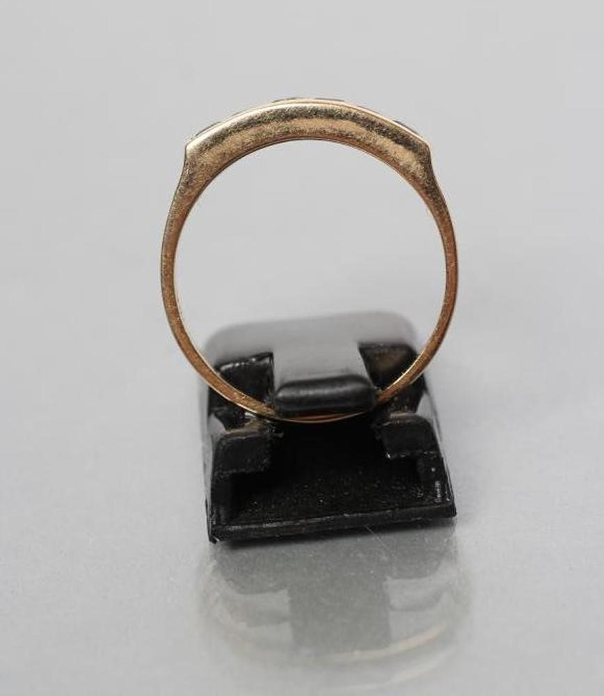 AN EMERALD HALF HOOP RING Image