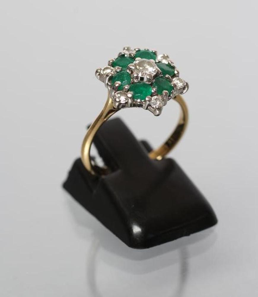 A DIAMOND AND EMERALD CLUSTER RING Image