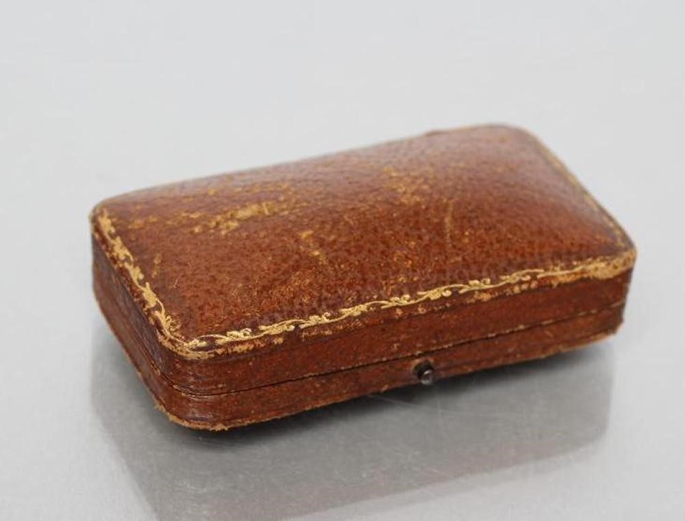 A LATE VICTORIAN BROOCH centred by an open back collet set round sapphire within seed pearl set Image