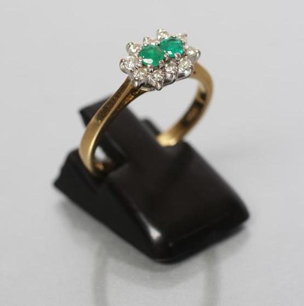 AN EMERALD AND DIAMOND CLUSTER RING Image