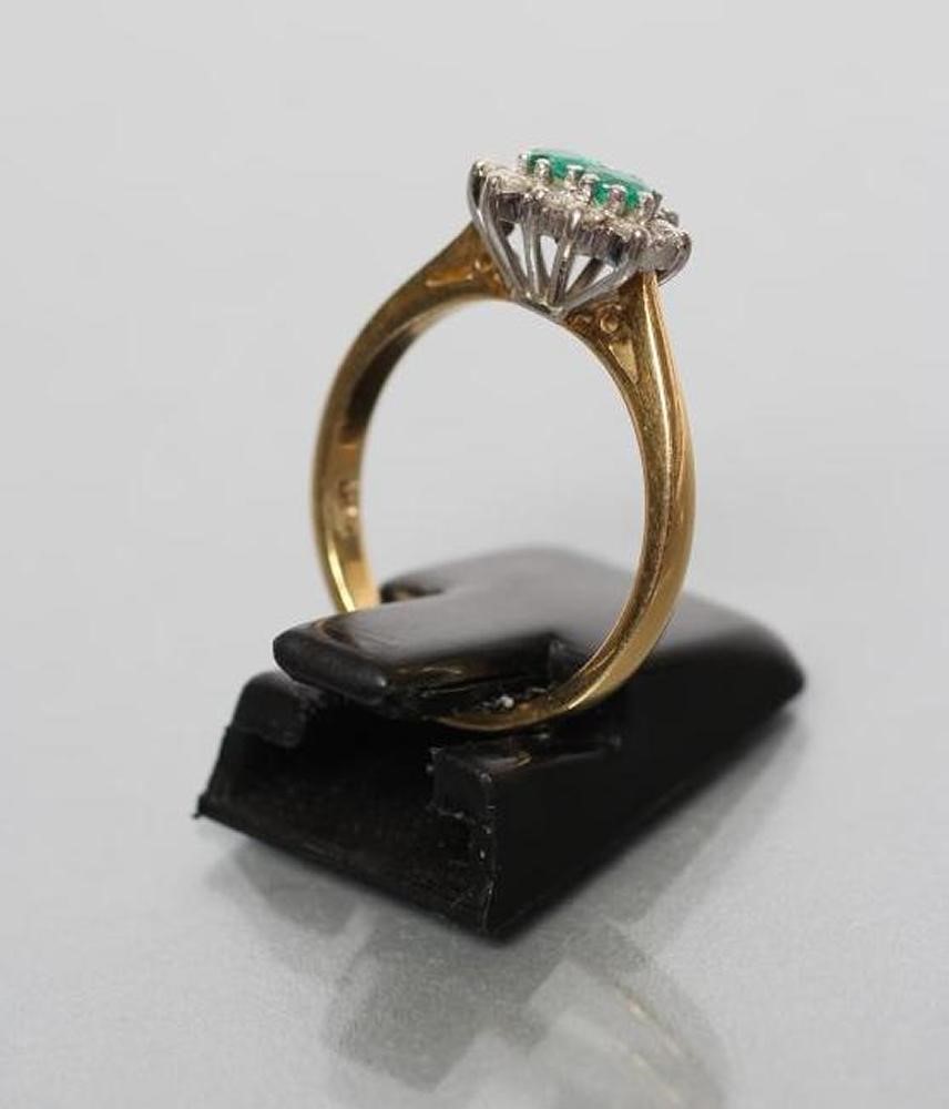 AN EMERALD AND DIAMOND CLUSTER RING Image