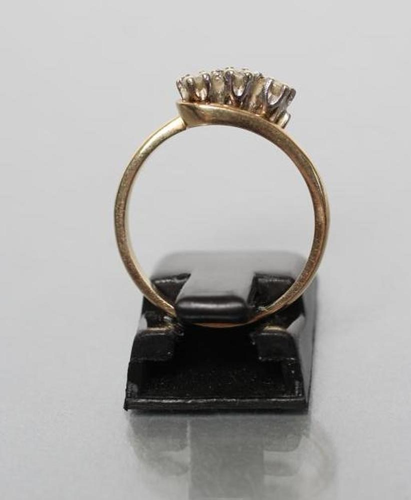 A THREE STONE DIAMOND CROSSOVER RING Image