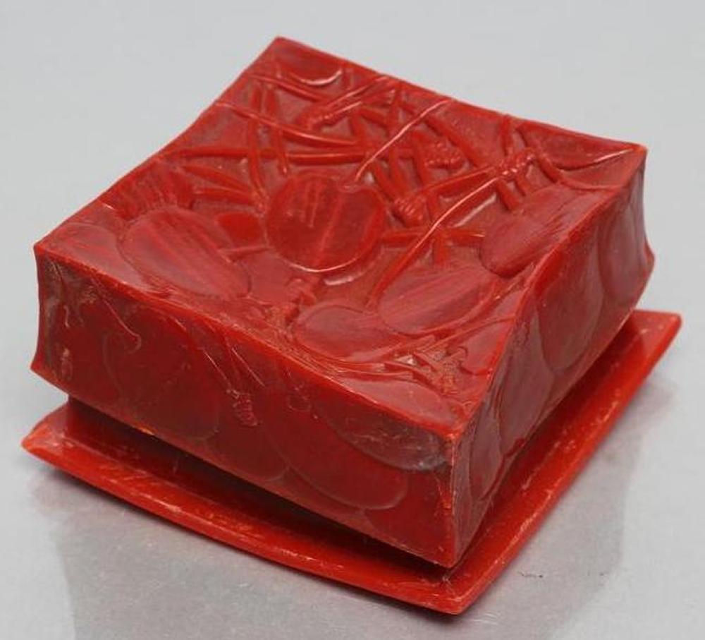 A LALIQUE RED BAKELITE DRESSING TABLE BOX AND COVER moulded in low relief with the "Cerises" pattern Image