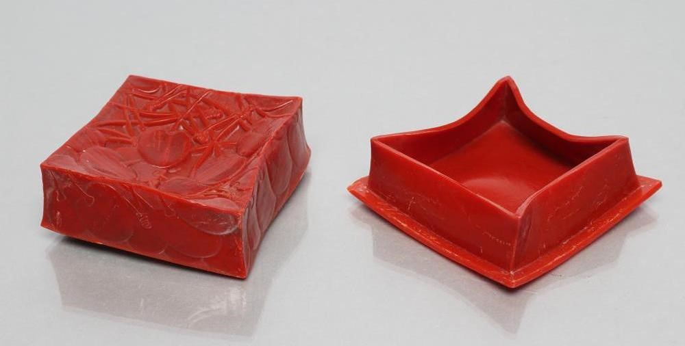 A LALIQUE RED BAKELITE DRESSING TABLE BOX AND COVER moulded in low relief with the "Cerises" pattern Image