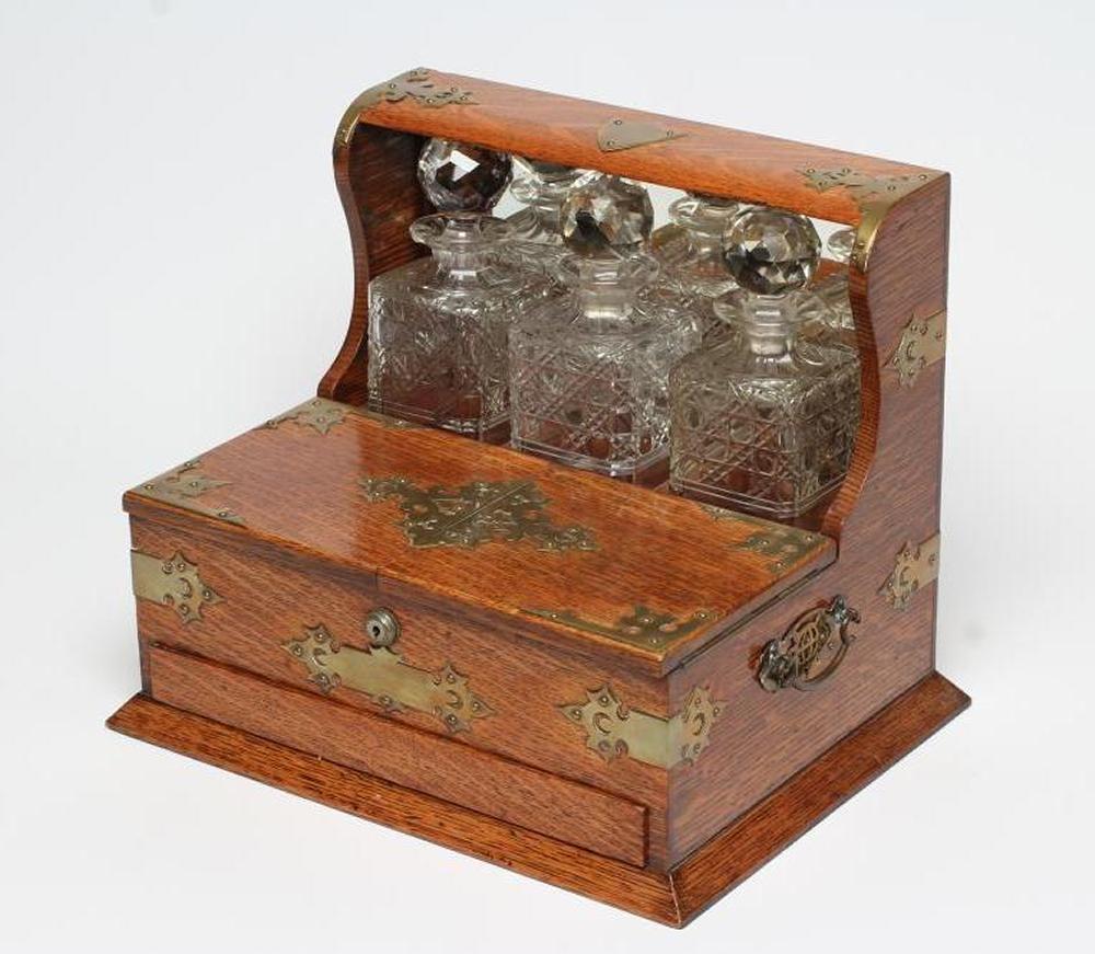 A LATE VICTORIAN OAK TRIPLE TANTALUS Image