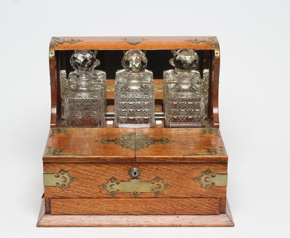 A LATE VICTORIAN OAK TRIPLE TANTALUS Image