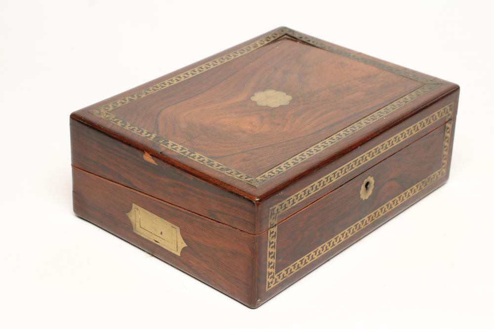 AN EARLY VICTORIAN ROSEWOOD WRITING BOX of rounded oblong form with pierced brass banding Image