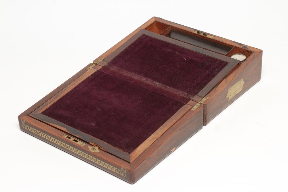 AN EARLY VICTORIAN ROSEWOOD WRITING BOX of rounded oblong form with pierced brass banding Image