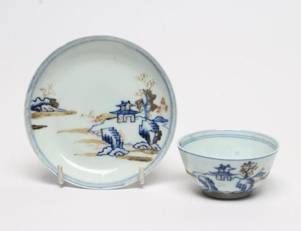 A NANKING CARGO CHINESE PORCELAIN TEA BOWL AND SAUCER painted in underglaze blue and overpainted in Image