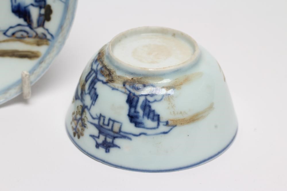 A NANKING CARGO CHINESE PORCELAIN TEA BOWL AND SAUCER painted in underglaze blue and overpainted in Image