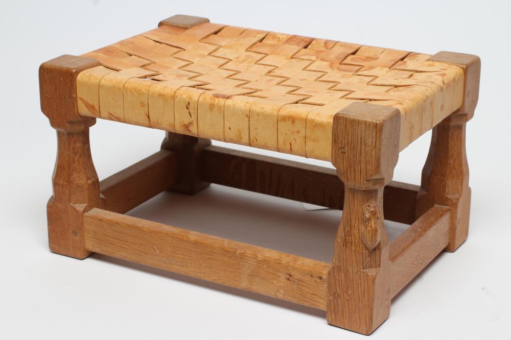 A ROBERT THOMPSON ADZED OAK FOOTSTOOL of oblong form with woven strap cow hide seat Image