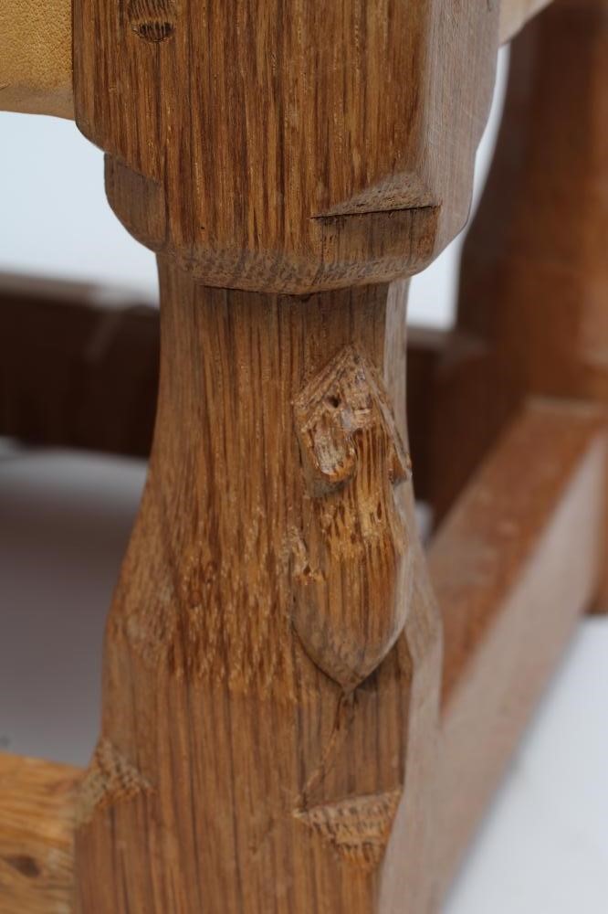 A ROBERT THOMPSON ADZED OAK FOOTSTOOL of oblong form with woven strap cow hide seat Image