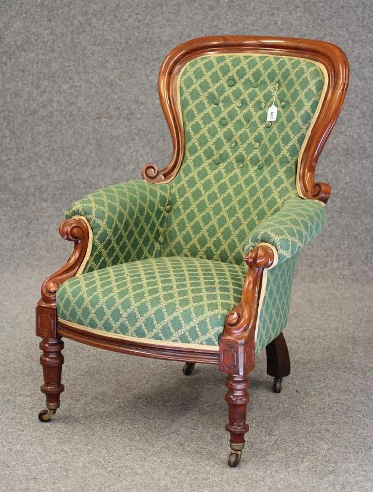 A VICTORIAN WALNUT FRAMED ARMCHAIR of spoon back form button upholstered in a cream and green weave Image