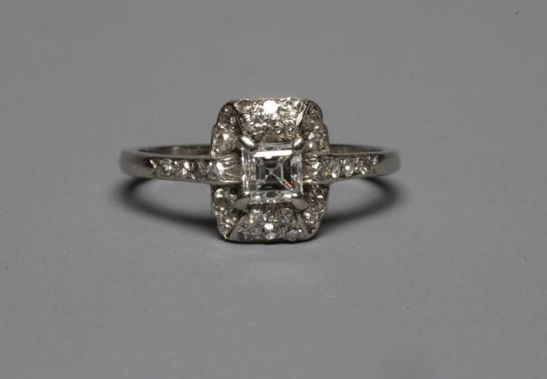 AN ART DECO DIAMOND COCKTAIL RING, the central Princess cut stone claw set to a domed border set Image