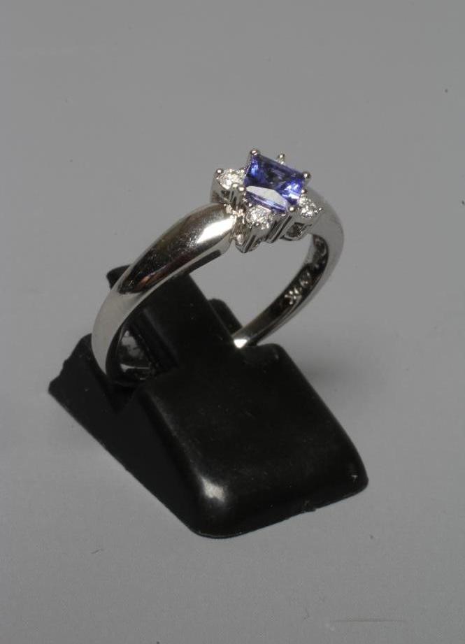 A TANZANITE AND DIAMOND RING, the square facet cut tanzanite claw set with four small diamonds to Image