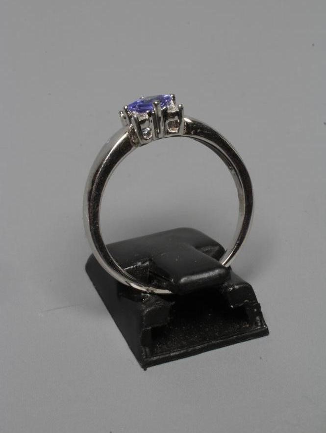 A TANZANITE AND DIAMOND RING, the square facet cut tanzanite claw set with four small diamonds to Image