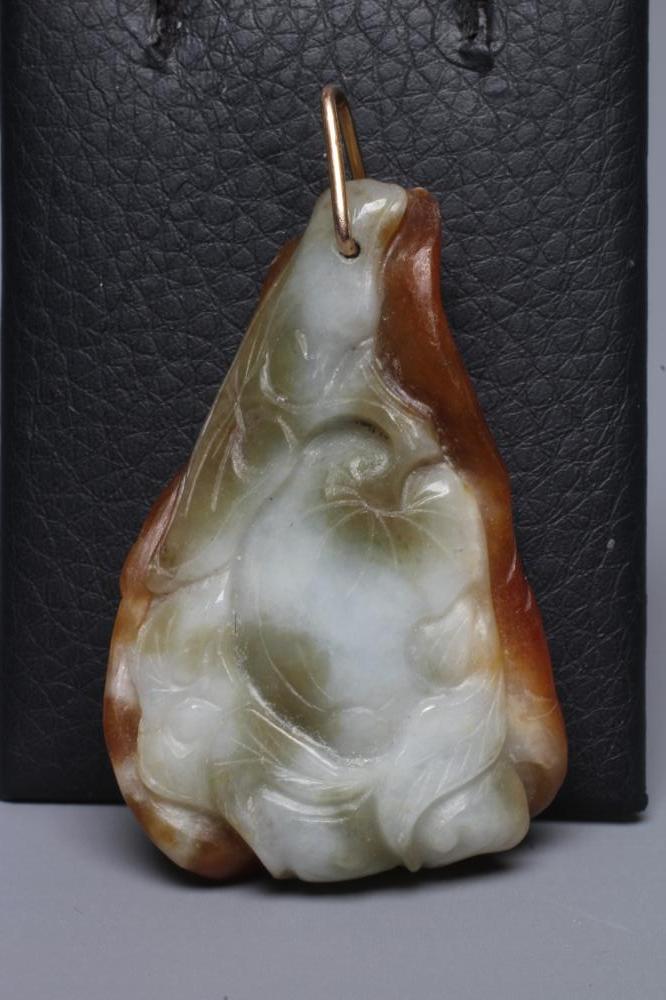 A CHINESE JADE PENDANT, one side carved as a hare (?) beside a flower, the other with a persimmon, Image