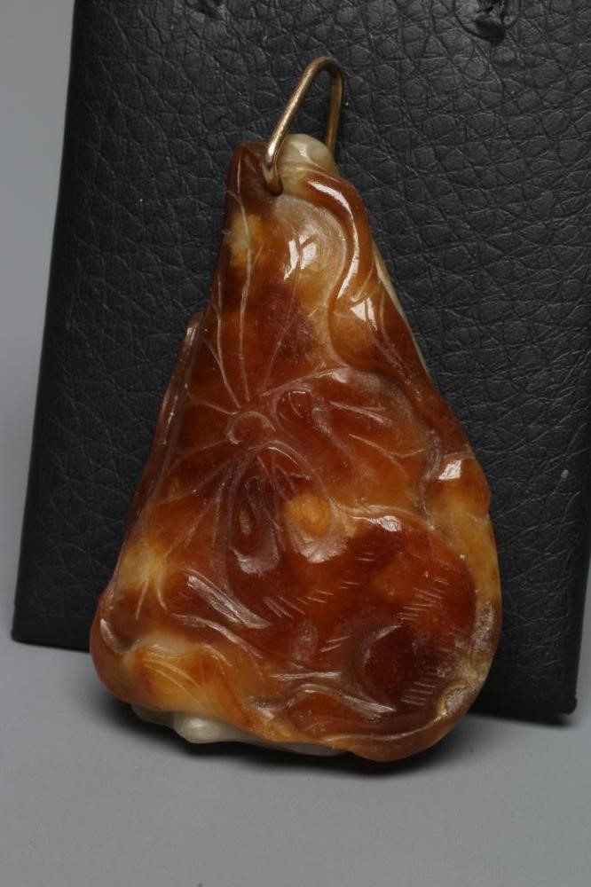 A CHINESE JADE PENDANT, one side carved as a hare (?) beside a flower, the other with a persimmon, Image